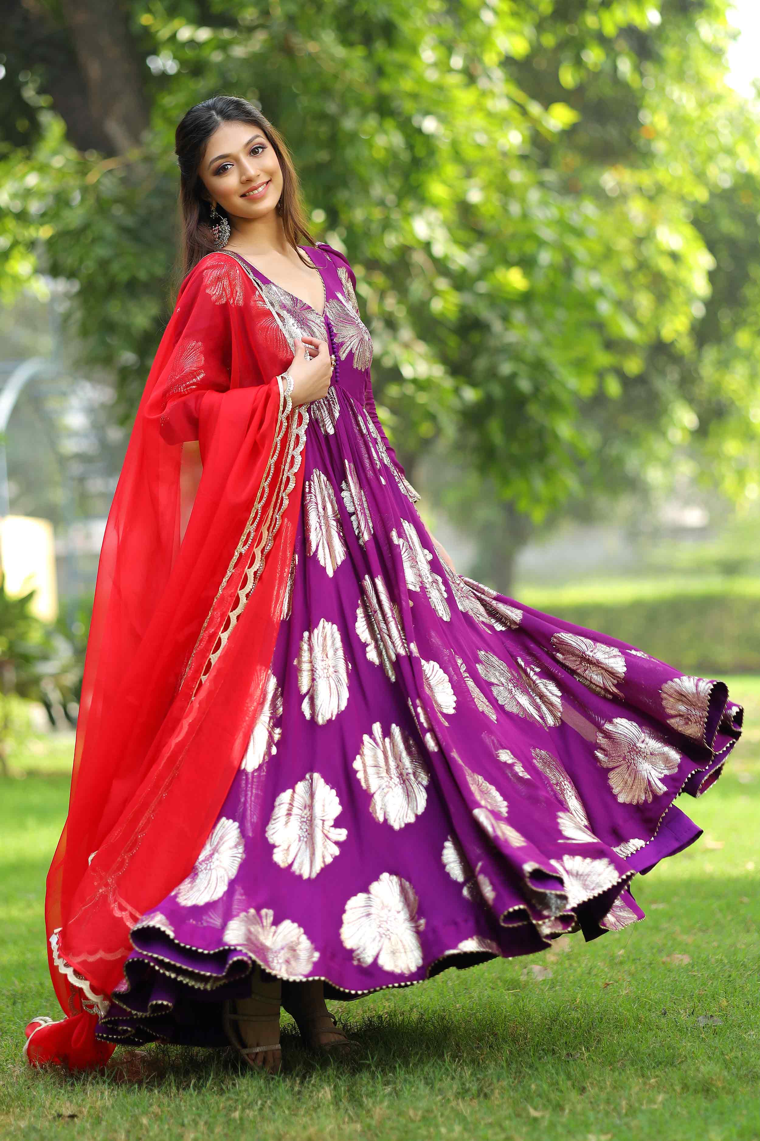 Flowing purple Anarkali suit with red dupatta in garden