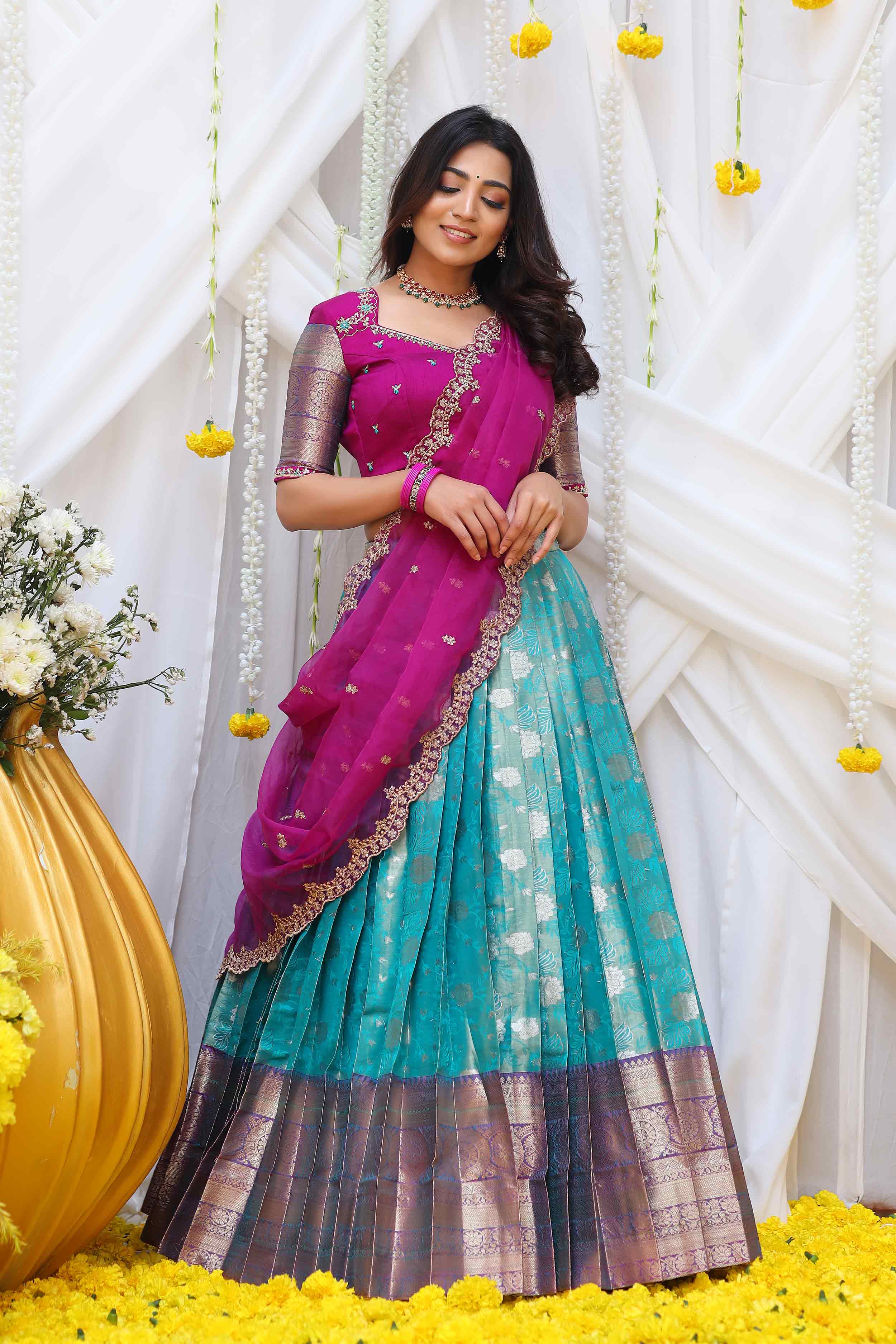 a woman in Turquoise and Magenta half saree