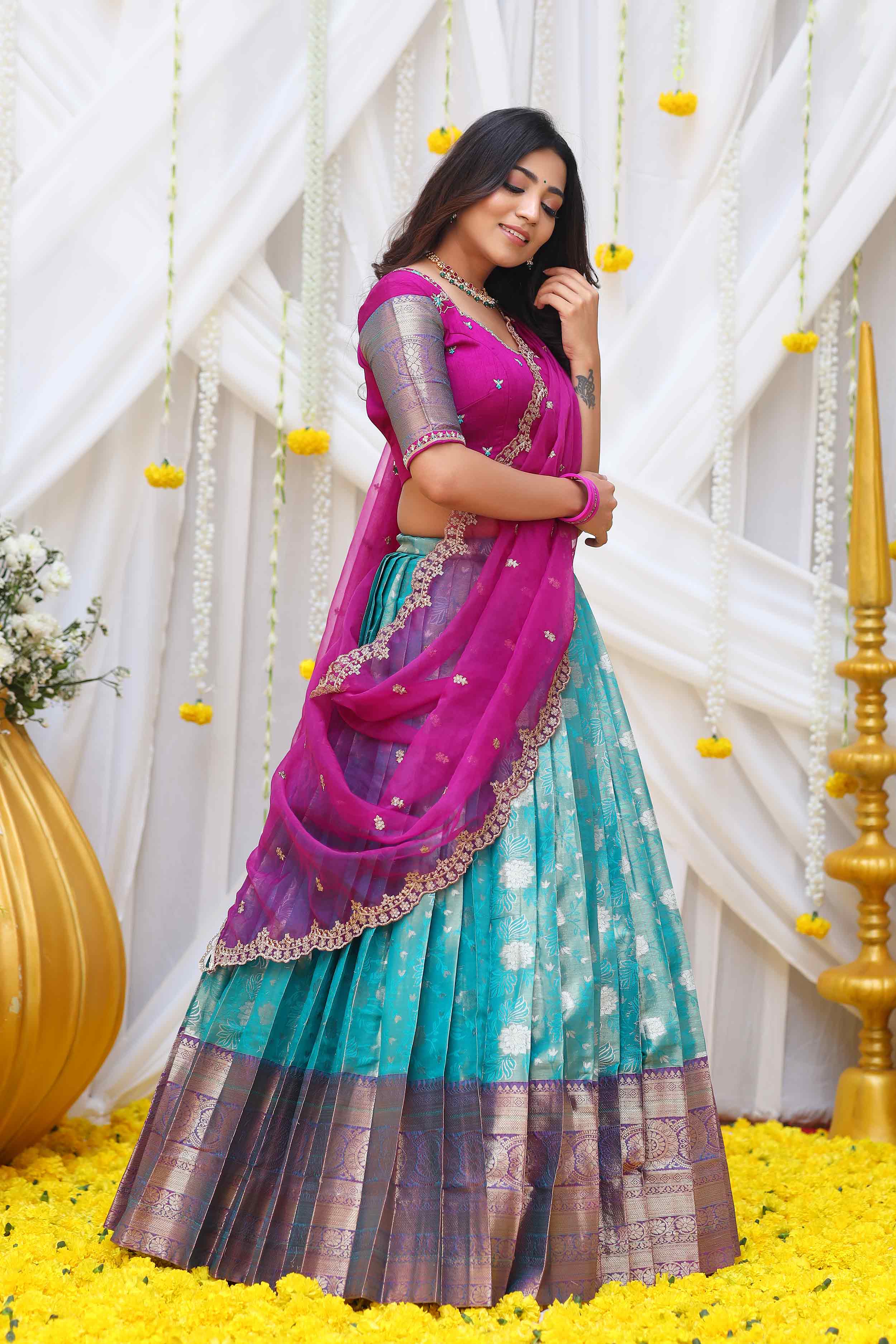 a woman in Turquoise and Magenta banarasi silk half saree