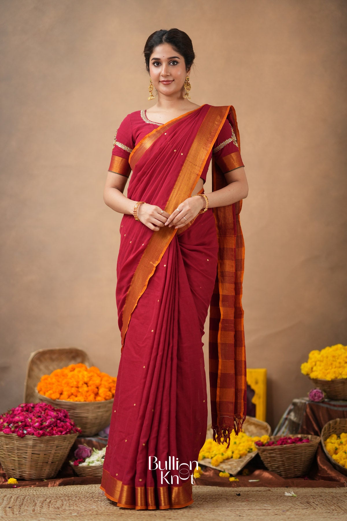 Woman wearing a red saree with Handcrafted blouse