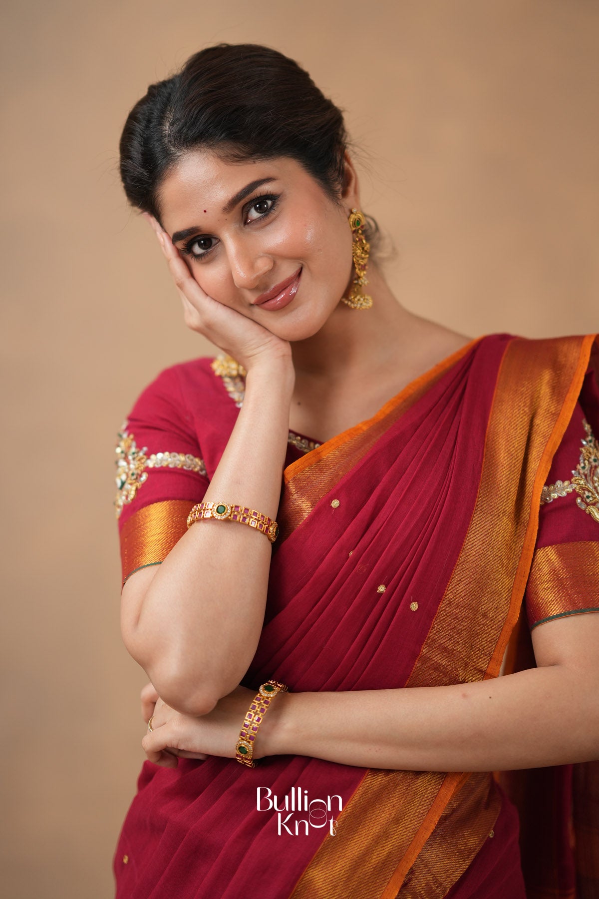 Woman wearing a red saree with gold border 