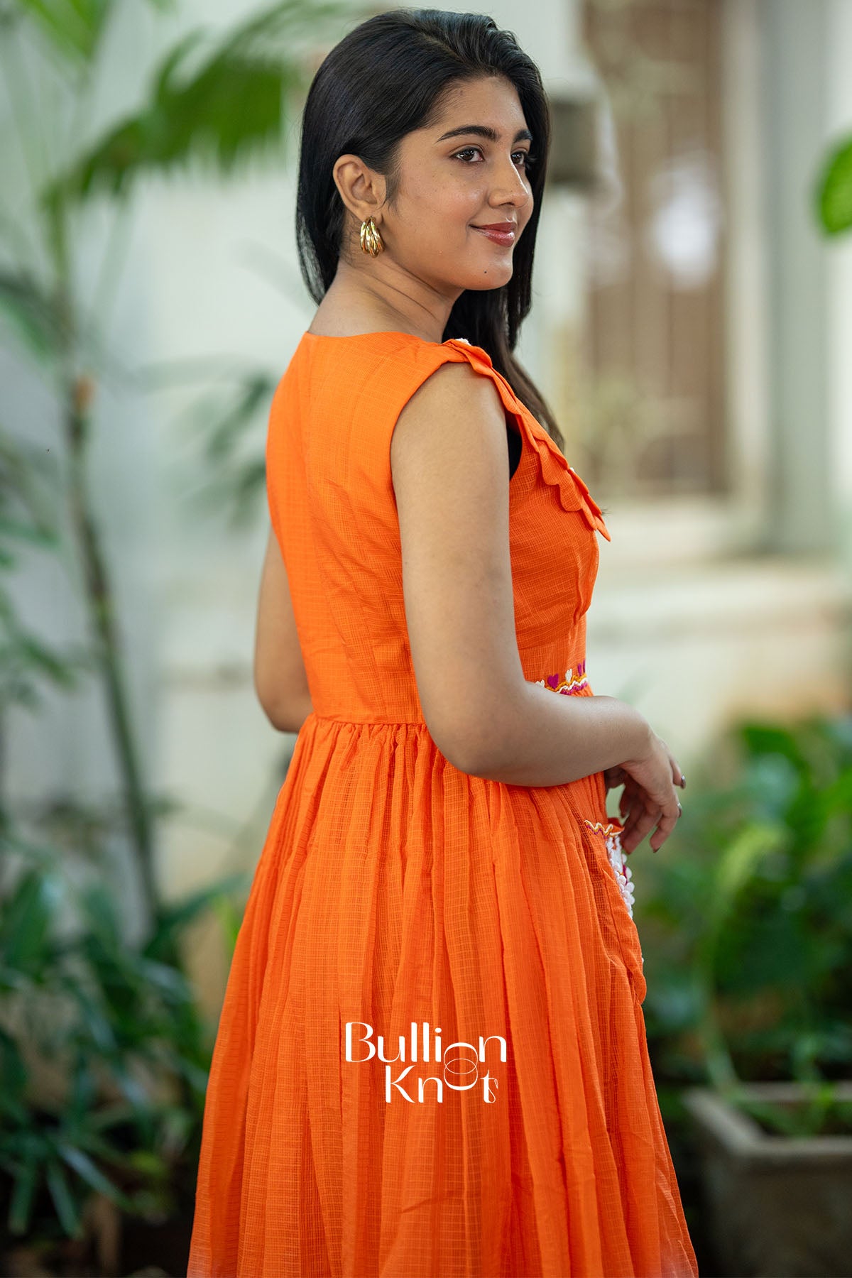 Woman wearing an orange dress with 'Bullisen Knit' branding