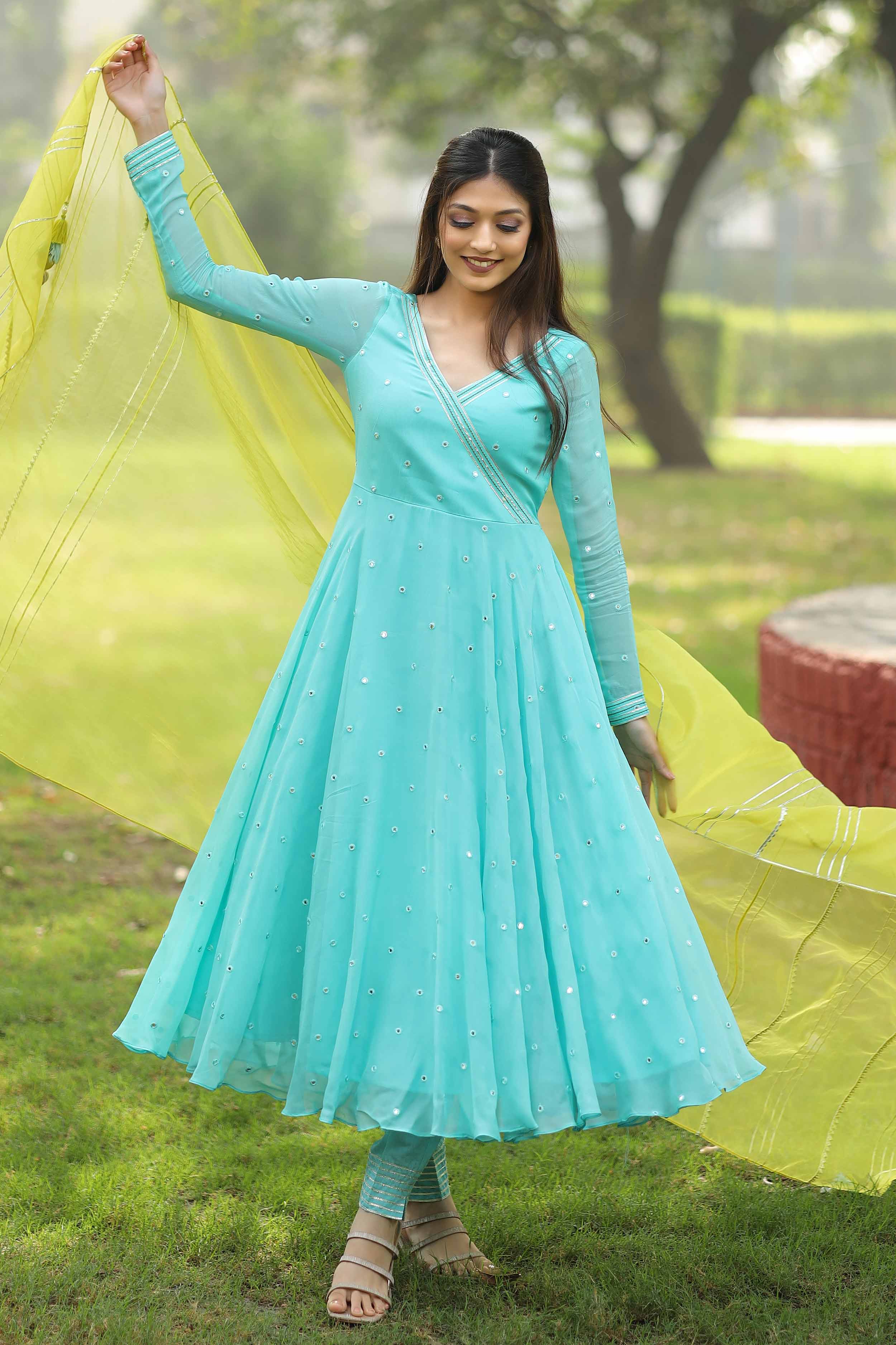 a woman in a blue dress holding a yellow dupatta dress name is Victoria Mirror Anarkali Set