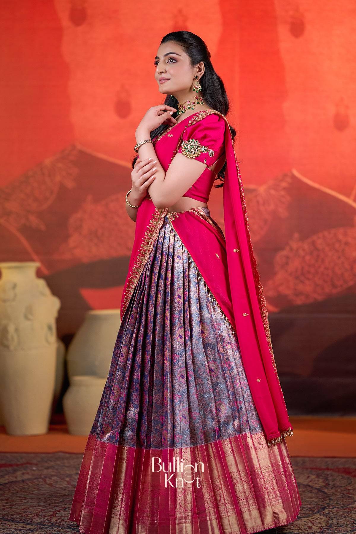 Side pose of model in Rithvika Banarasi Lehenga Set in Pink at bullionknot highlighting the rich Banarasi skirt and traditional styling.