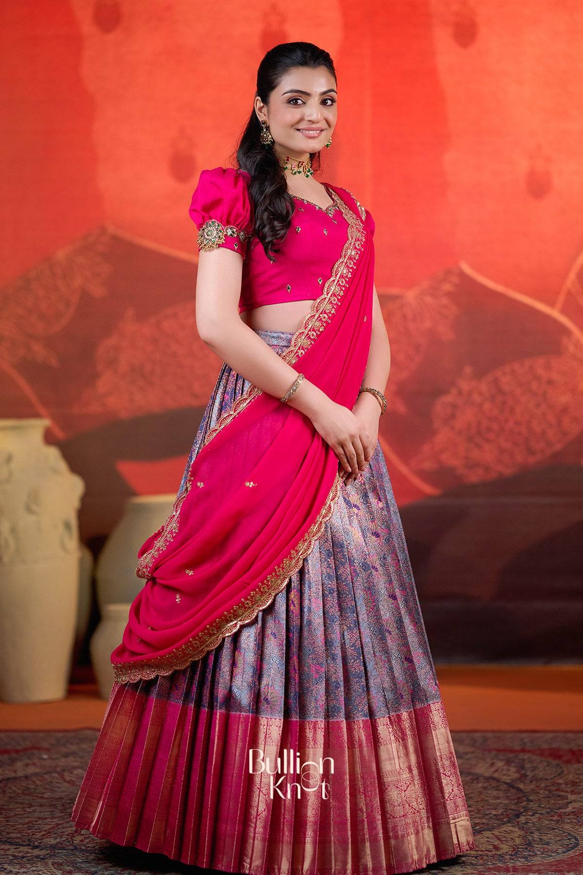 Front-facing view of Rithvika Banarasi Lehenga Set in Pink at bullionknot with puffed sleeves and gold embroidered dupatta.