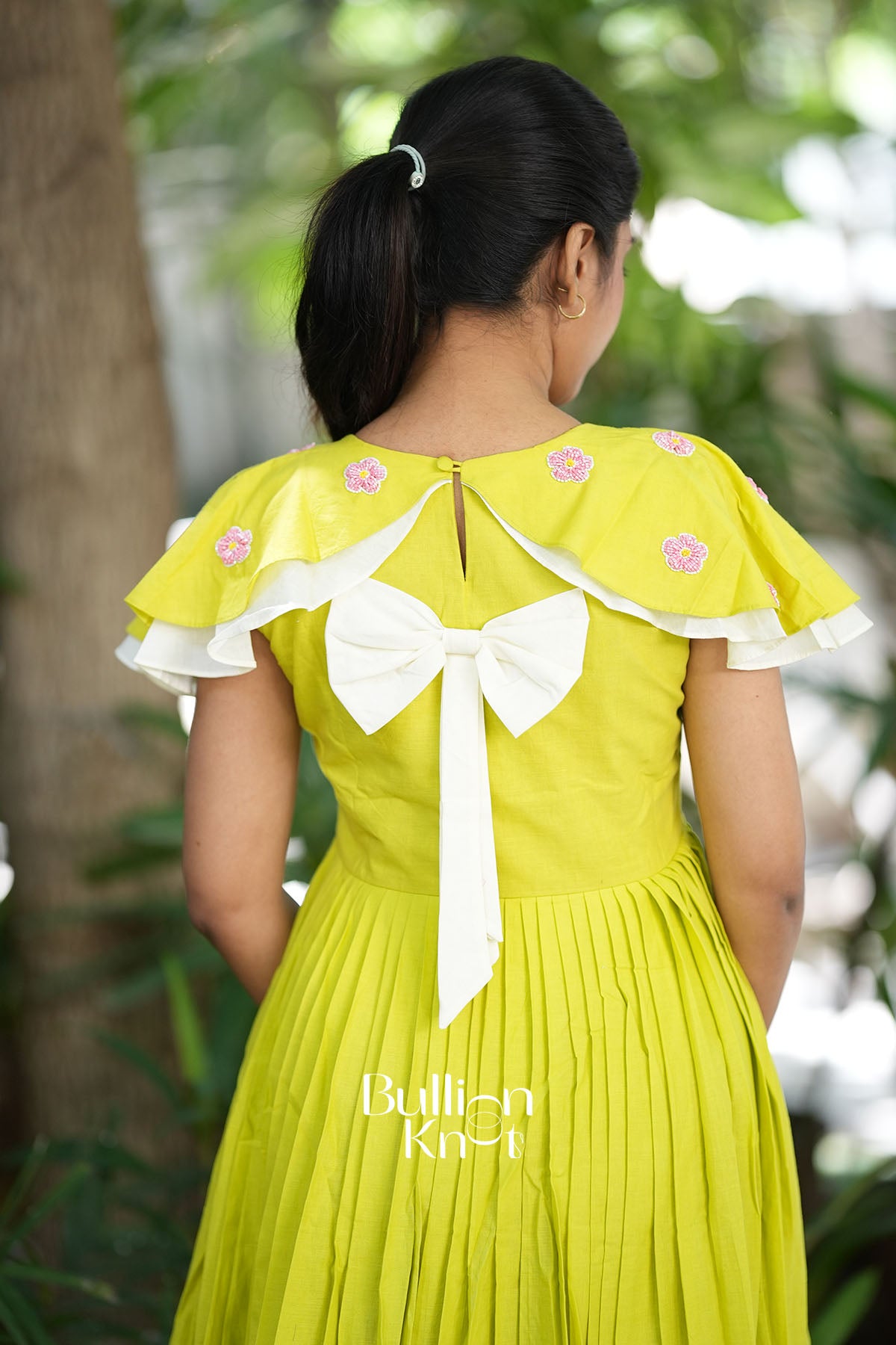 Back view of lime fluttery cape sleeves dress