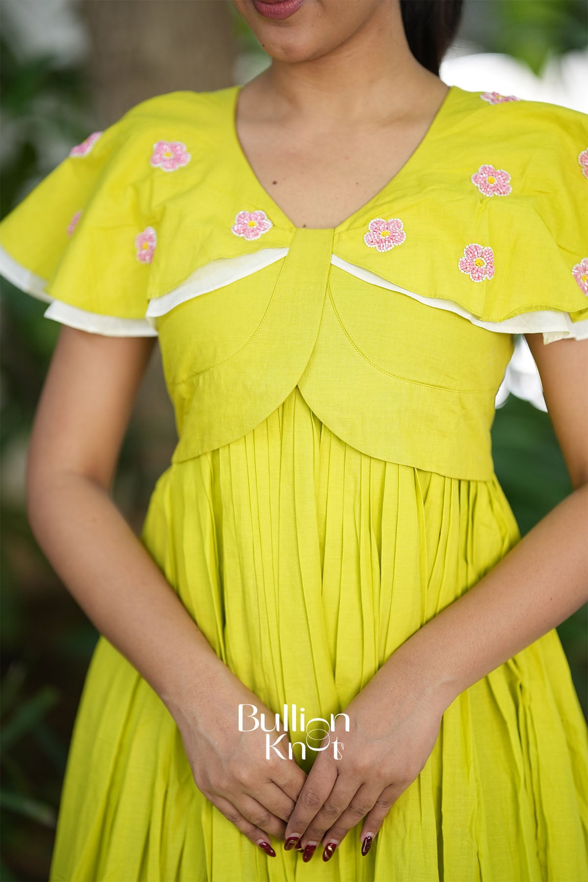 Close-up of fluttery cape sleeves on lime midi dress