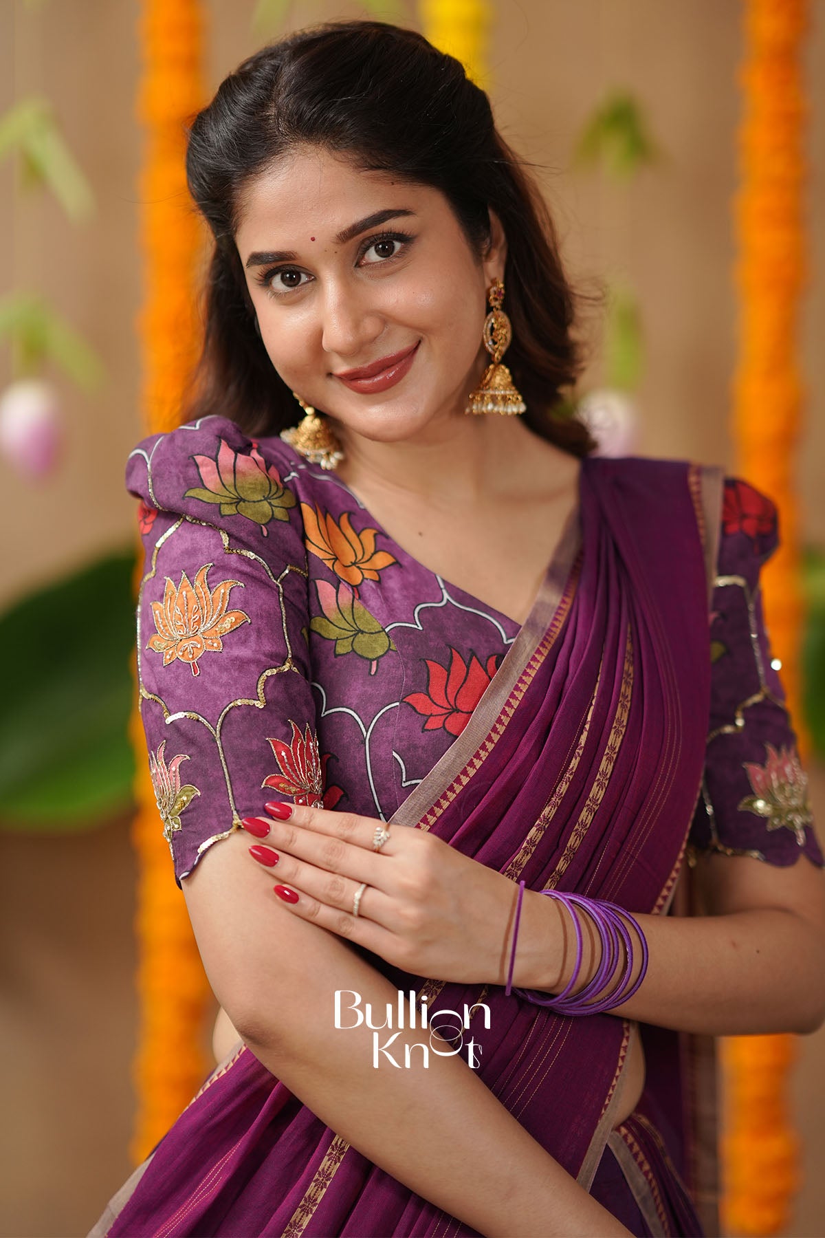Woman in a purple saree with floral patterns